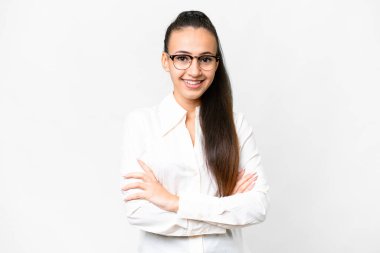 İzole edilmiş beyaz arka planda genç bir Arap kadın kollarını ön cephede çapraz tutuyor.