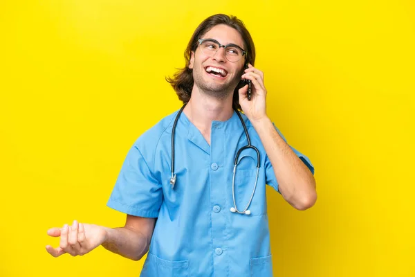 Young Surgeon Caucasian Man Isolated Yellow Background Keeping Conversation Mobile — Stock Photo, Image