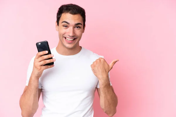 Νεαρός Καυκάσιος Άνδρας Απομονωμένος Ροζ Φόντο Χρησιμοποιώντας Κινητό Τηλέφωνο Και — Φωτογραφία Αρχείου