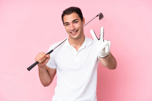 年轻的高尔夫球手男子孤身一人 背景粉红 面带微笑 显示出胜利的迹象 — 图库照片