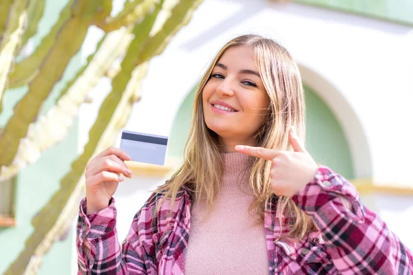Młoda Ładna Rumuńska Kobieta Trzyma Kartę Kredytową Zewnątrz Celuje Nią — Zdjęcie stockowe