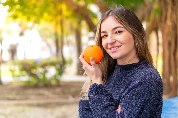 年轻漂亮的罗马尼亚女人在户外拿着橙子 — 图库照片