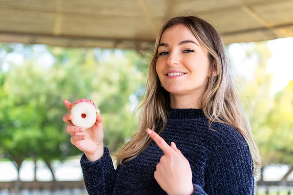Jonge Mooie Roemeense Vrouw Houdt Een Donut Buitenlucht Wijzen — Stockfoto