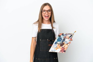 Litvanyalı genç bir kadın elinde palet tutarken beyaz arka planda şaşırtıcı bir yüz ifadesi var.