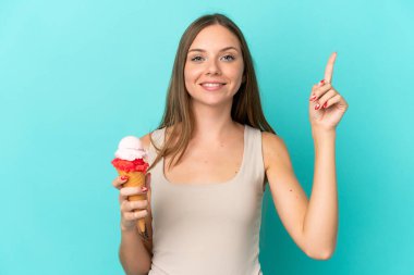 Young Lithuanian woman with cornet ice cream isolated on blue background pointing up a great idea