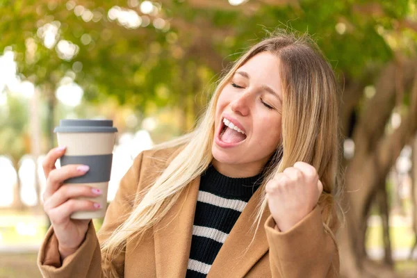 Mladý Pěkný Blondýnka Žena Drží Odnést Kávu Venku Slaví Vítězství — Stock fotografie