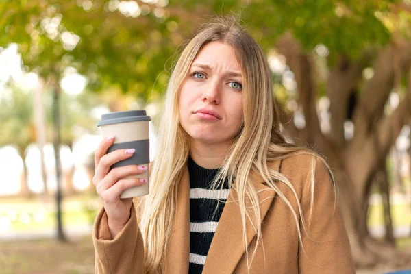 Mladý Pěkný Blondýnka Žena Drží Odnést Kávu Venku Smutným Výrazem — Stock fotografie