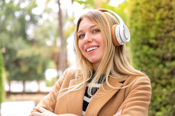 Νεαρή Όμορφη Ξανθιά Γυναίκα Ακούει Μουσική Ακουστικά Εξωτερικούς Χώρους Χέρια — Φωτογραφία Αρχείου