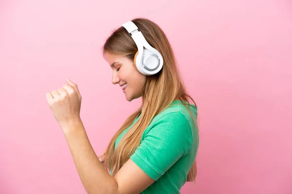 Νεαρή Ξανθιά Γυναίκα Απομονωμένη Ροζ Φόντο Ακούγοντας Μουσική Και Χορεύοντας — Φωτογραφία Αρχείου
