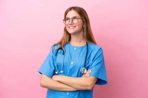 年轻的外科医生妇女 背靠粉红的背景 面带微笑地抬起头 — 图库照片