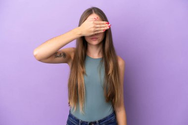 Genç Litvanyalı bir kadın mor arka planda, gözleri elleriyle kapatıyor. Bir şey görmek istemiyorum.