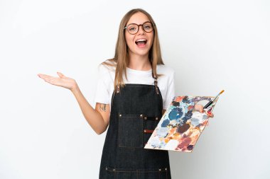 Elinde palet tutan Litvanyalı genç bir sanatçı beyaz arka planda şok olmuş yüz ifadesiyle izole edilmiş.