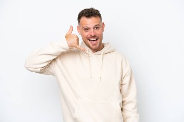 Beyaz arka planda izole edilmiş beyaz, yakışıklı genç bir adam telefon jesti yapıyor. Bana geri dönüş işareti ver.