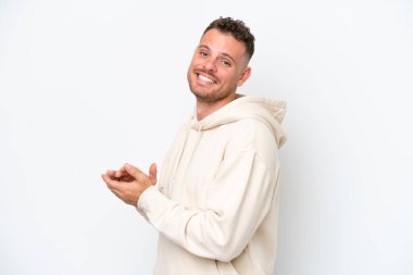 Beyaz arka planda izole edilmiş beyaz tenli yakışıklı adam alkışlıyor.