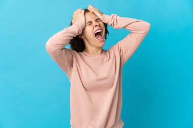 Mavi arka planda izole edilmiş genç İngiliz kadın bunalıma girdi.