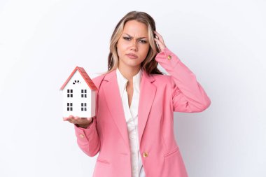 Rus emlakçı elinde oyuncak ev tutuyor. Beyaz arka planda izole edilmiş. Şüpheleri var.