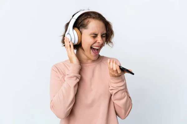 Νεαρή Αγγλίδα Απομονωμένη Λευκό Φόντο Ακούγοντας Μουσική Κινητό Και Τραγουδώντας — Φωτογραφία Αρχείου