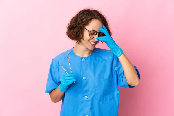 英国女牙医在粉色背景笑中把工具放在一边 — 图库照片