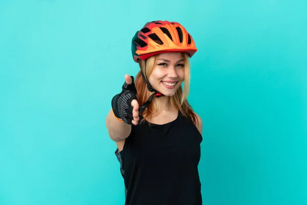 Joven Ciclista Chica Sobre Aislado Fondo Azul Estrechando Las Manos — Foto de Stock