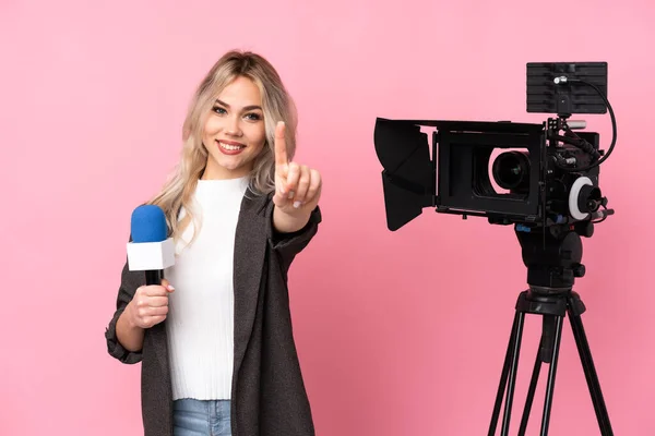 レポーター女性マイクを保持し 指を示すと持ち上げる孤立したピンクの背景の上にニュースを報告 — ストック写真