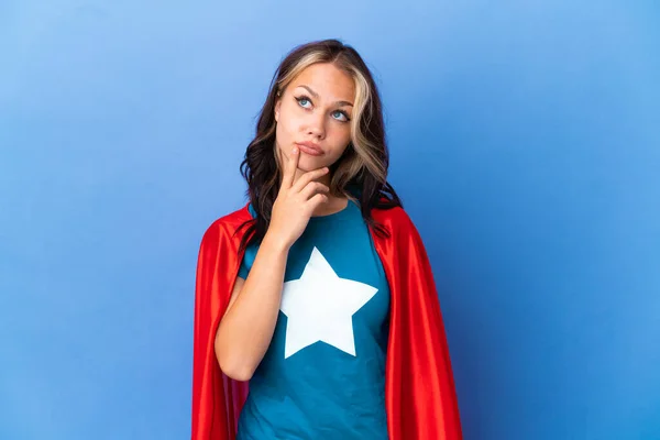 Super Héroe Adolescente Chica Aislado Sobre Fondo Azul Teniendo Dudas —  Fotos de Stock