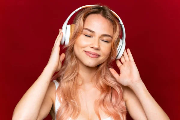 Chica Adolescente Con Pelo Rosa Escuchando Música Sobre Fondo Rojo — Foto de Stock