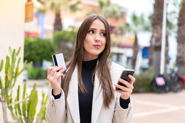Młoda Piękna Kobieta Zewnątrz Kupuje Pomocą Telefonu Komórkowego Kartą Kredytową — Zdjęcie stockowe