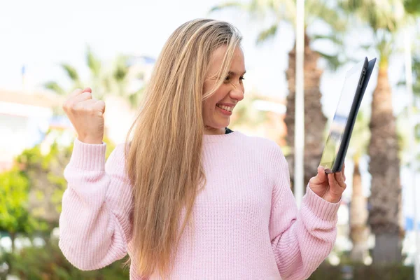 Ung Blond Kvinna Håller Tablett Utomhus Firar Seger — Stockfoto