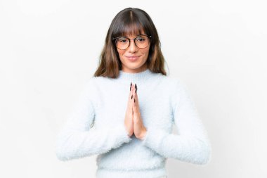 Young caucasian woman over isolated white background keeps palm together. Person asks for something