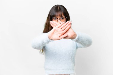 Young caucasian woman over isolated white background making stop gesture with her hand to stop an act