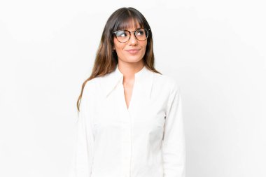 Kafkas kökenli genç bir kadın, beyaz arka planda izole edilmiş bir şekilde yukarı bakarken bir fikir düşünüyor.