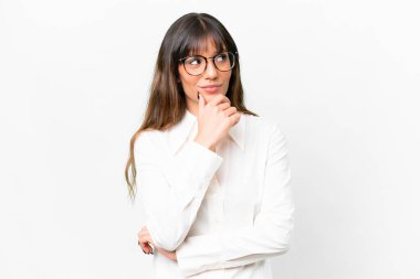 İzole edilmiş beyaz arka planda genç beyaz kadın yan bakıyor ve gülümsüyor.