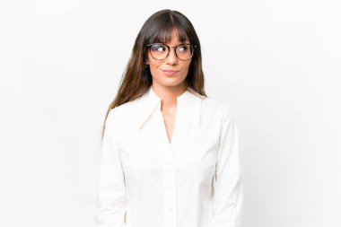 İzole edilmiş beyaz arka planda genç beyaz kadın şüpheli hareketler yapıyor.