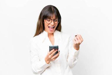 Young caucasian woman over isolated white background with phone in victory position