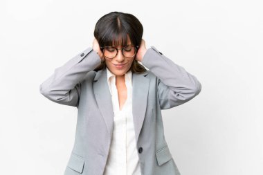 İzole edilmiş beyaz arka planda genç beyaz kadın hayal kırıklığına uğramış ve kulaklarını kapatmış.