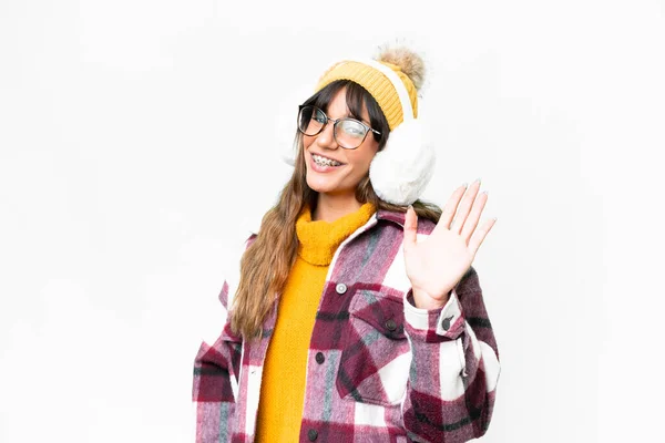 Young Caucasian Woman Wearing Winter Muffs Isolated White Background Saluting — 스톡 사진