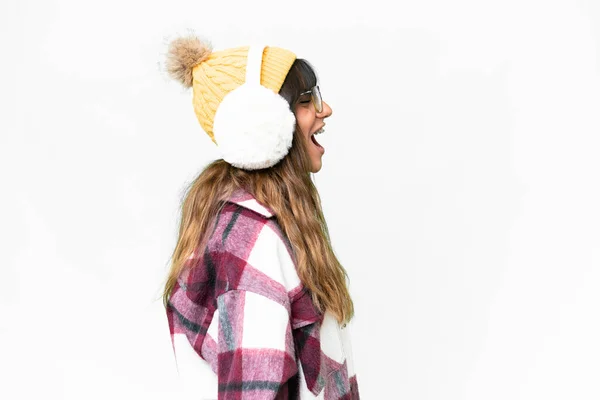 年轻的高加索女人披着冬衣 在孤独的白色背景上 侧身笑着 — 图库照片