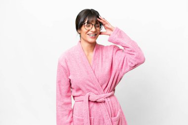 İzole edilmiş beyaz arka planı olan bornozlu genç bir kadın çok gülümsüyor.