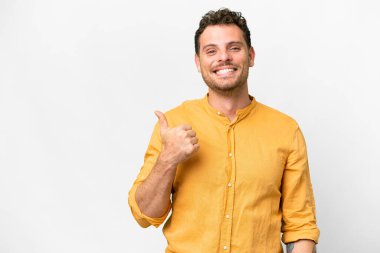 İzole edilmiş beyaz arka plan üzerinde Brezilyalı bir adam bir ürün sunmak için kenarı işaret ediyor