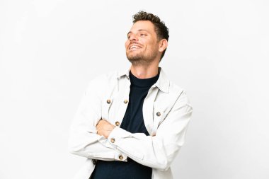 İzole edilmiş beyaz arka planı olan Brezilyalı adam mutlu ve gülümsüyor.