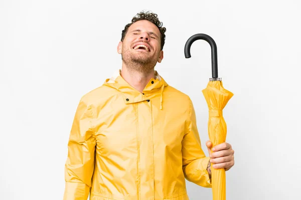 ブラジル人男性とともにレインプルーフコートと傘上の隔離された白い背景笑い — ストック写真