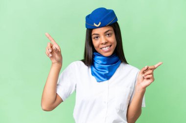 Uçak hostesi Afrikalı Amerikalı kadın izole edilmiş arka planda parmak göstererek...