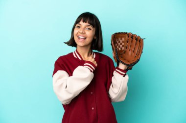 Beyzbol eldivenli genç melez kadın mavi arka planda zaferi kutluyor.