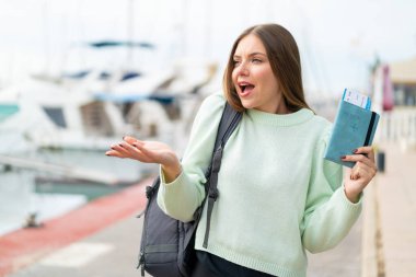 Genç, güzel, sarışın bir kadın elinde pasaport tutarken yüzünde sürpriz bir ifade vardı.