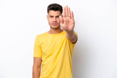 Beyaz arka planda izole edilmiş genç beyaz adam dur hareketi yapıyor.