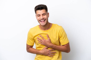 Beyaz arka planda izole edilmiş genç beyaz adam çok gülümsüyor.