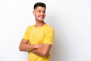 Beyaz arka planda izole edilmiş, kolları çapraz ve mutlu genç beyaz bir adam.