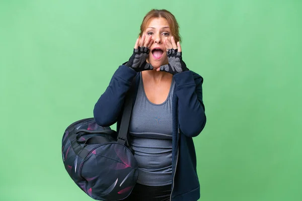 中年スポーツ女性とともにスポーツバッグ上の隔離された背景叫びと何かを発表 — ストック写真