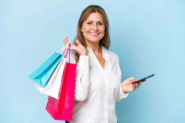 Middle Aged Caucasian Woman Isolated Blue Background Holding Shopping Bags — 스톡 사진