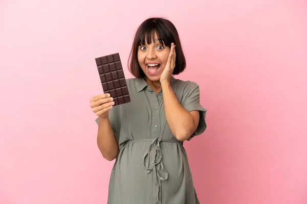 Žena Nad Izolovaným Pozadím Těhotná Drží Čokoládu Překvapeným Výrazem — Stock fotografie